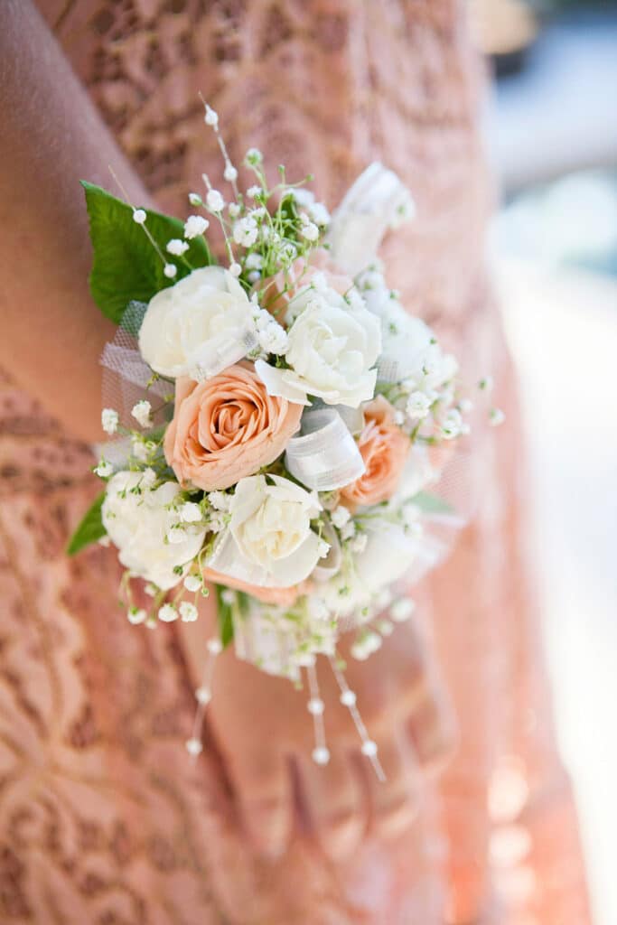 A bridesmaid in a textured dress with an intricate corsage.