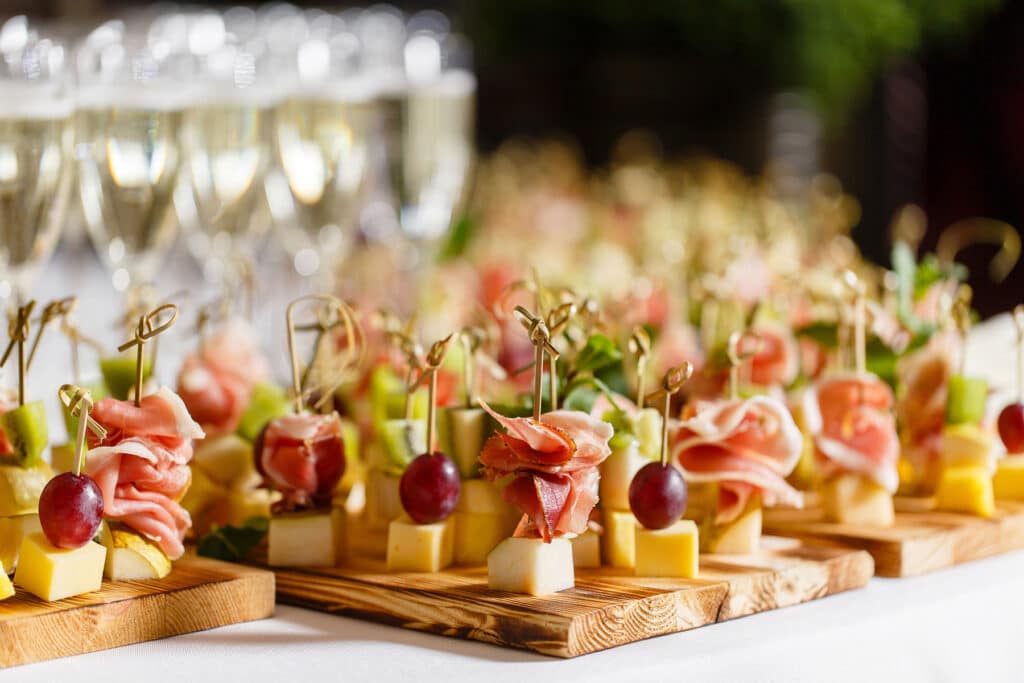 A board of charcuterie skewer appetizers and champagne.