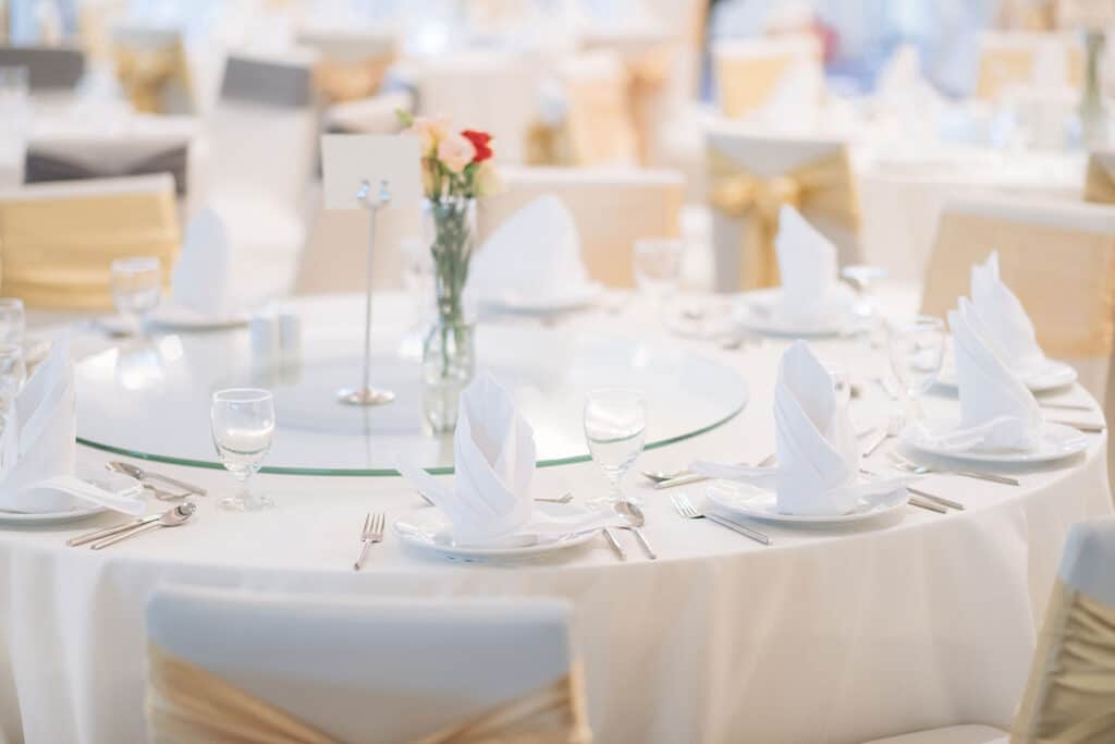 An table prepared with elegant white table settings.