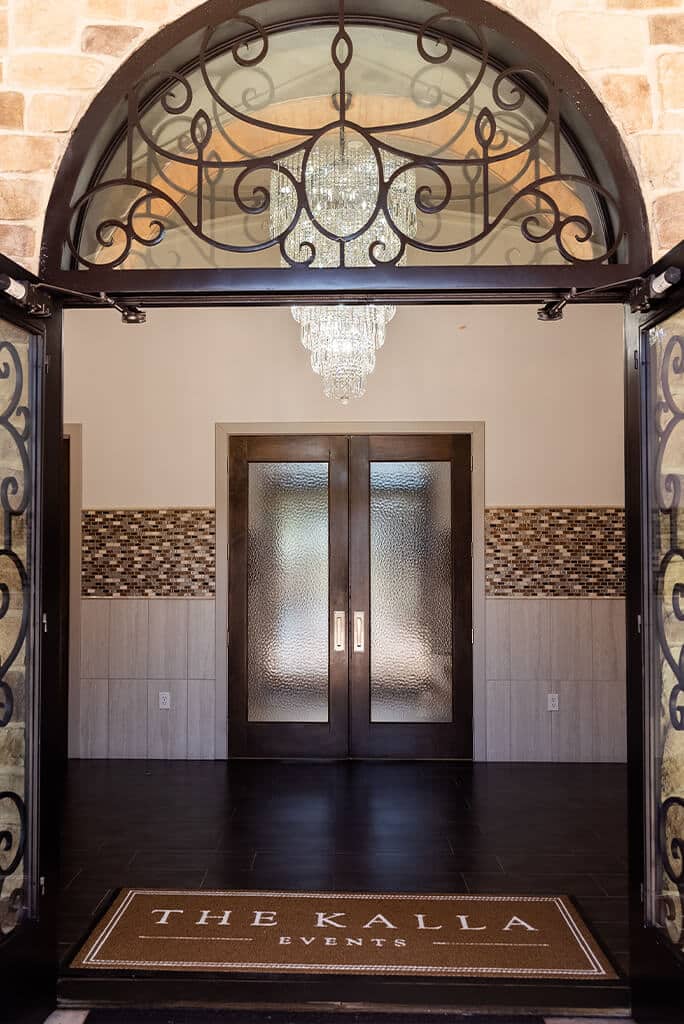 Double doors opened with frosted glass and a "The Kalla Events" welcome mat.